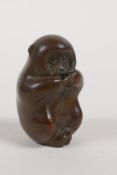 A Japanese bronze okimono incense stick holder in the form of a monkey, impressed mark to base,