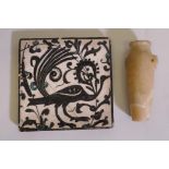 An antique Islamic tile, with glazed decoration depicting a peacock, cracked, 6" x 6", and alabaster