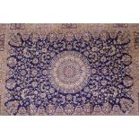 A blue ground Kashmir rug with a floral shabaz medallion design, 74" x 54"