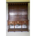 A Georgian oak Welsh potboard dresser, the upper rack with shaped frieze and two shelves, the base
