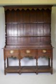 A Georgian oak Welsh potboard dresser, the upper rack with shaped frieze and two shelves, the base