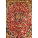 A full pile rich pink ground Persian carpet, hand woven with floral medallion design and blue