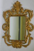 An Italian style giltwood wall mirror, with carved and pierced frame surmounted by a feathered