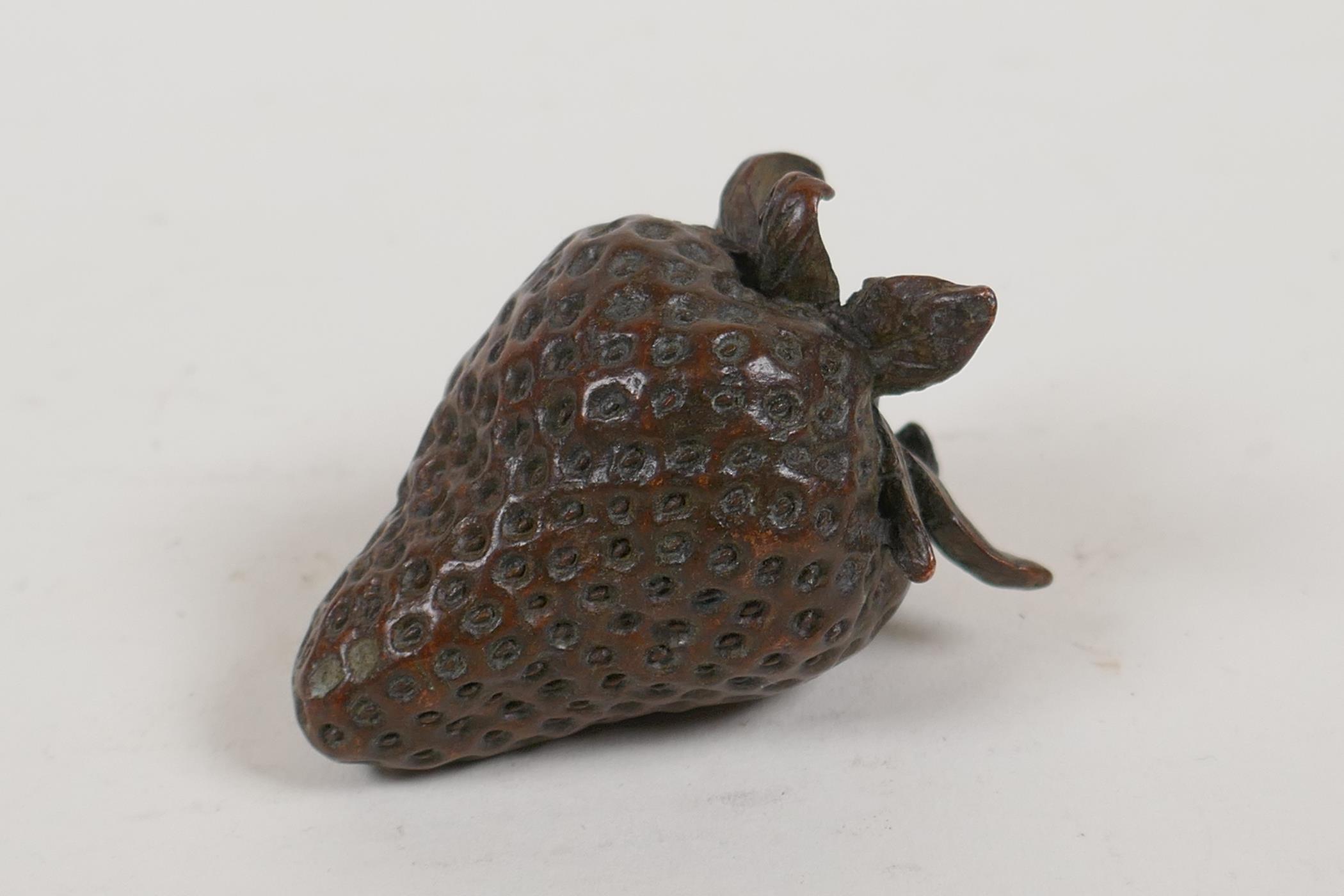 A Japanese bronze okimono in the form of a strawberry, 2" long