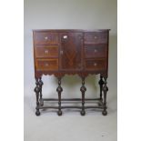 A C19th walnut cabinet on stand, with feather banded inlaid decoration, six drawers and central