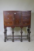 A C19th walnut cabinet on stand, with feather banded inlaid decoration, six drawers and central