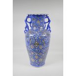 A Persian blue ground pottery two handled vase, with Iznik style scrolling decoration, signed to