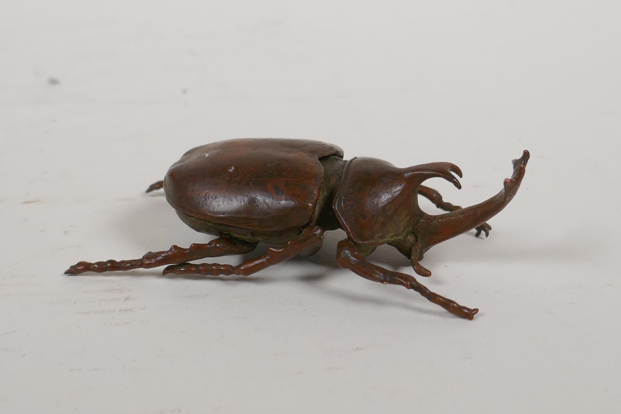 A Japanese Jizai style okimono in the form of a rhinoceros beetle, the carapace opening to reveal an