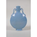 A blue glazed porcelain moon flask with two handles and underglaze stylised lotus flower