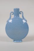 A blue glazed porcelain moon flask with two handles and underglaze stylised lotus flower