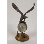 A bronze and glass ball desk clock surmounted by an eagle, 8" high