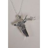 A sterling silver whistle with stag head decoration, on a silver chain, 1½" long