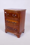 A yew wood three drawer bow front bedside chest of drawers with brass drop handles, 25" x 19" x 14"