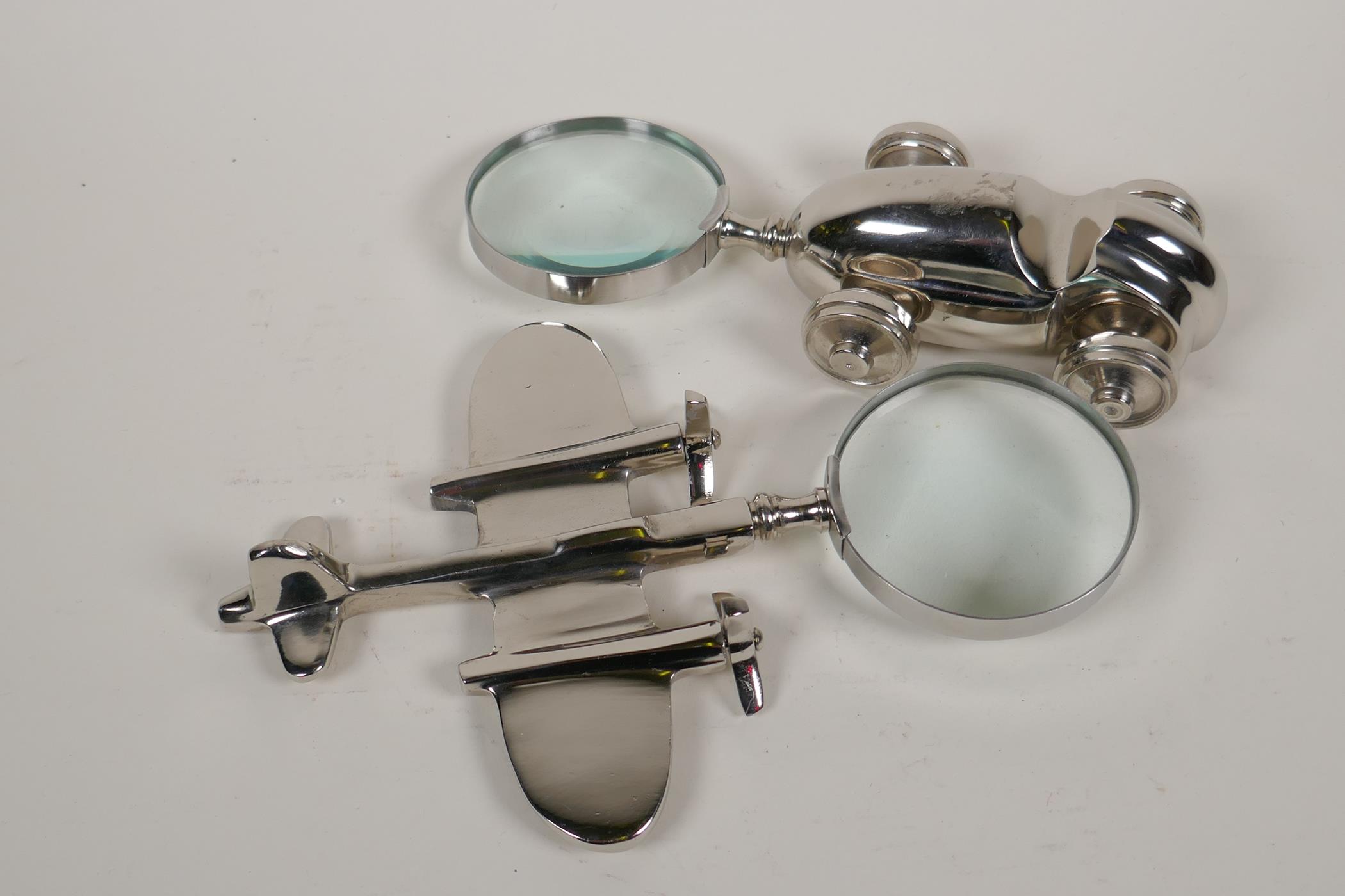 Two plated desk top magnifying glasses in the form of a racing car and an aeroplane, 9" long