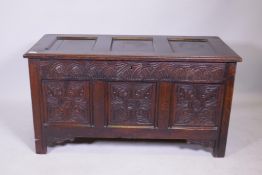 An C18th oak triple panel oak coffer with carved panels and frieze, raised on stile supports, 46"