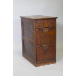 An early C20th oak office filing cabinet, two small over two larger drawers, with panelled sides and