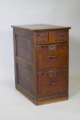 An early C20th oak office filing cabinet, two small over two larger drawers, with panelled sides and