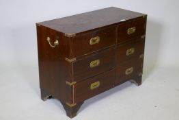 A campaign style mahogany cabinet with three drawers and cupboard with false drawer front, inset