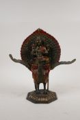 A Sino Tibetan painted and gilt bronze Buddha riding a phoenix, 10" high