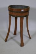 An antique oak jardiniere constructed from a coopered barrel