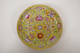 A yellow ground porcelain dish with famille rose enamel decoration of the eight Buddhist symbols,