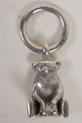 A silver pendant teddy bear and a hoop