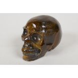 A carved tiger's eye skull, 2½" high