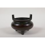 A Chinese two handled censer on tripod supports, impressed character mark to base, 4" diameter