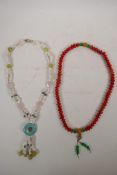 A string of red seed kernel mala beads with jade style feature beads, and a white agate, hardstone