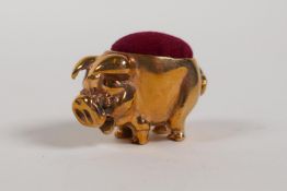 A miniature brass pinchushion in the form of a pig, 1" long