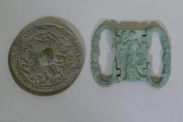 A Middle Eastern metal buckle with serpent decoration and central panel depicting a man bearing a