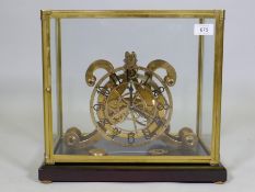 A brass skeleton clock, the open dial with enamelled Arabic numeral, housed in a brass and glass
