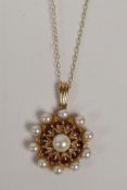 A 9ct gold garnet and pearl pendant, on a 9ct chain, 1" drop