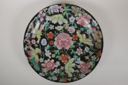 A C19th Chinese famille noir dish with floral decoration, 6 character GuangXu mark to base, AF