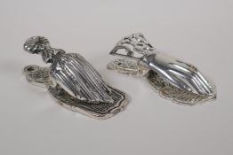 A silvered metal paper clip in the form of a hand, and another similar, 5" long