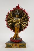 A Sino Tibetan gilt and painted bronze figure of a many armed deity, 12½" high