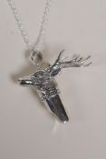 A sterling silver whistle with stag head decoration, on a silver chain, 1½" long