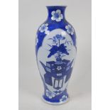 A Chinese blue and white porcelain vase with painted panels of flowers on a table, on a floral and