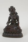 A Sino Tibetan bronze figure of a goddess seated on a lotus throne, 6½" high