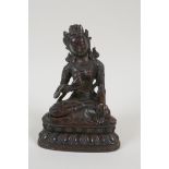 A Sino Tibetan bronze figure of a goddess seated on a lotus throne, 6½" high