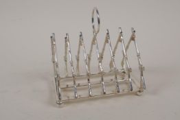 A silver plated toast rack modelled as a rifle rack, 4" long