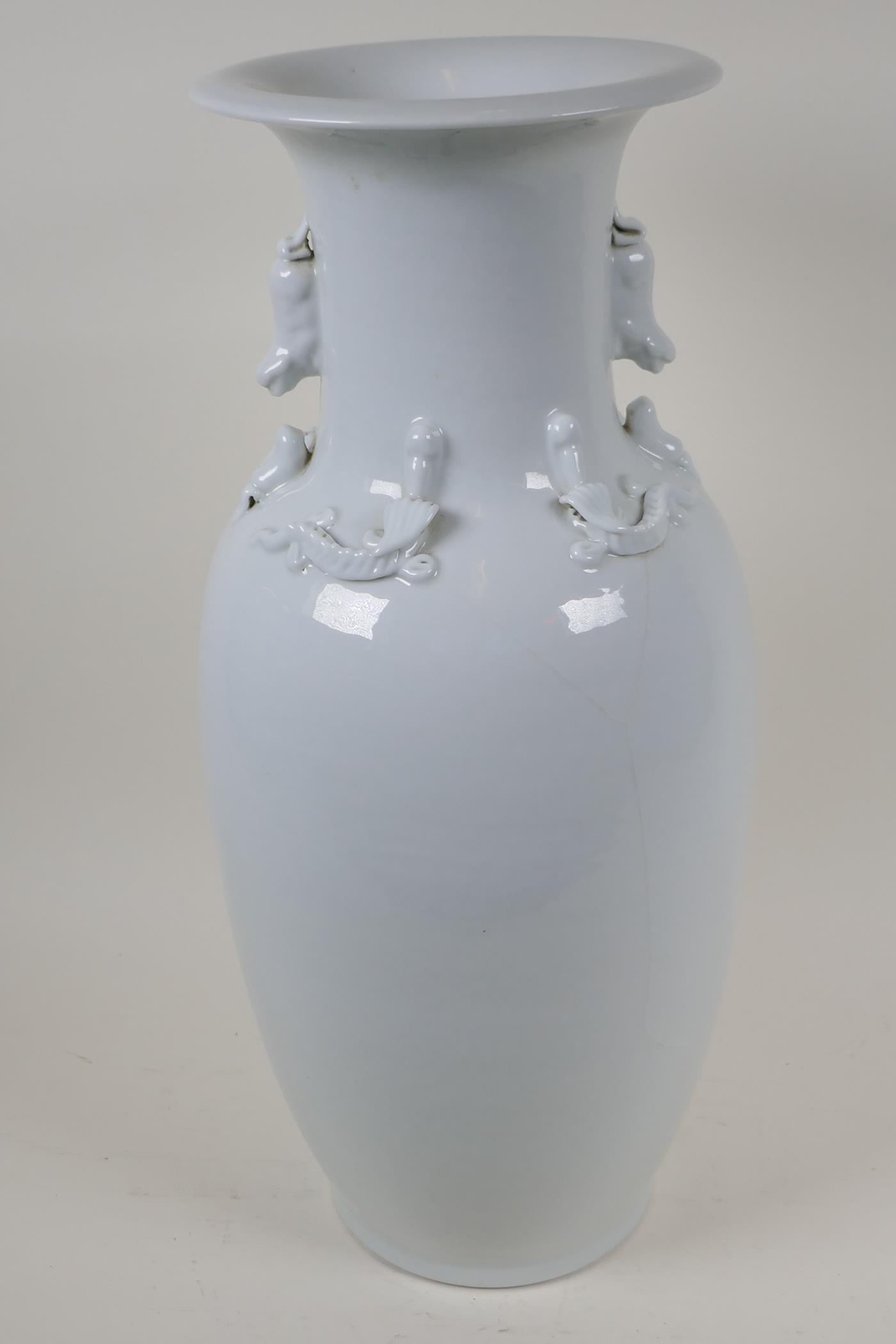 A Chinese blanc de chine porcelain vase with twin fo dog handles, the shoulder embossed with