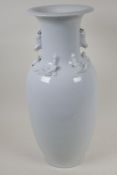 A Chinese blanc de chine porcelain vase with twin fo dog handles, the shoulder embossed with