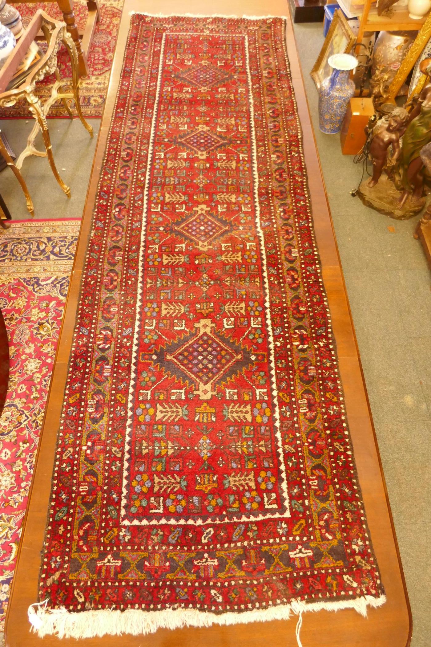 A thick pile red ground hand woven Persian Heriz runner with a cross medallion design, 42" x 138", - Image 2 of 7