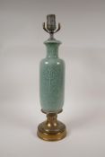 A brass and celadon glazed porcelain lamp, with underglaze floral decoration, 18" high