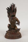 A Sino Tibetan bronze figure of a wrathful deity, with coppered and gilt patina, 8½" high