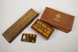 Two bridge card boxes containing cards and score sheets, a wooden bridge marker, a brass and wood