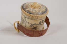 A carved bone tape measure with floral decoration, 2"