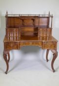 A C19th continental figured mahogany desk, the upper section with open shelves and four drawers
