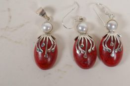 A suite of silver and coral stone set earrings and pendant